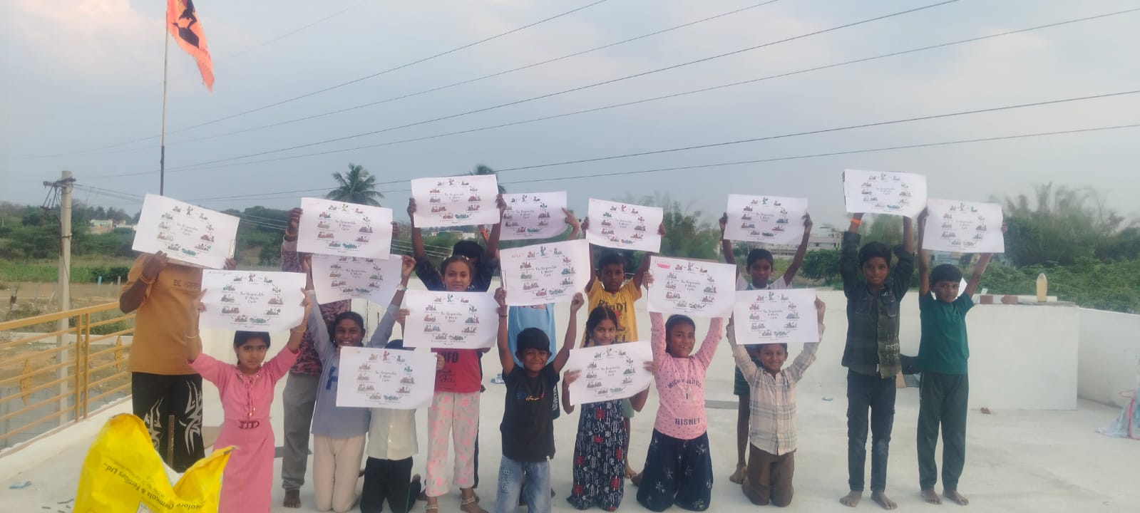 Student holding illustrated e-waste awareness poster at school event