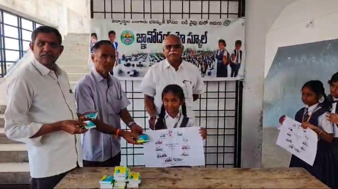 A schoolgirl holds up an E-Waste Cycle poster as school officials hand over booklets at Jnanodaya High School.